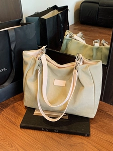 Minimalist light green tote bag with pink shoulder strap and silver chain detail