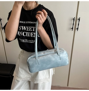 Close-up of light blue PU leather baguette bag with dual slim straps and zipper detail