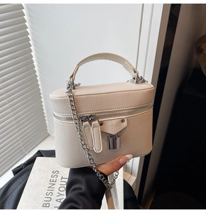 Detail of white lychee leather box bag with silver chain strap and mini lock charm