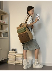 Detailed view of color-block backpack with khaki nylon fabric and green zipper pocket
