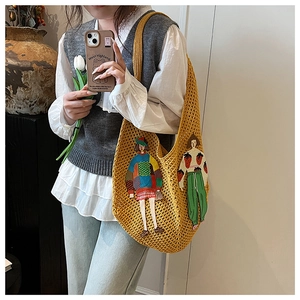 Detail of yellow knit tote bag featuring cartoon appliques and soft woven texture