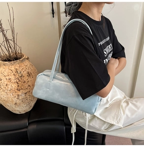 Detail view of the light blue shoulder bag with vintage texture and sleek zipper design