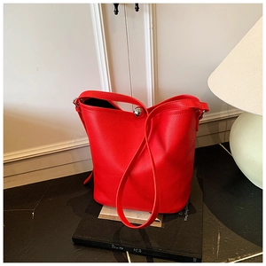 Détail du sac seau en cuir grainé rouge avec fermeture à cadenas en métal brillant