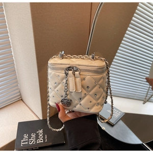 Dettaglio mini borsa trapuntata con strass e ciondolo a forma di rosa argentata