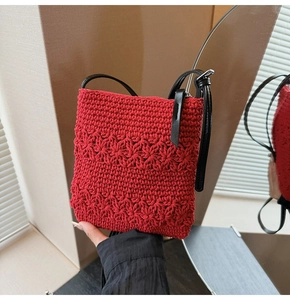 Close-up of red thick yarn crochet pattern and texture on small square crossbody bag
