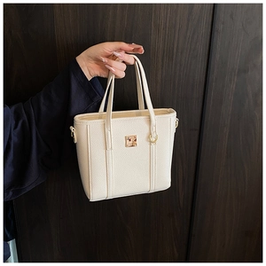 Close-up of beige lychee texture PU leather bucket bag with square gold metal buckle
