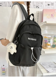 Close-up of black nylon backpack featuring white RKDBAG embroidery and plush star charm