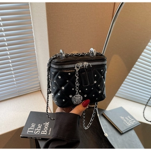 Dettaglio mini borsa a scatola nera trapuntata con cristalli e ciondolo camelia