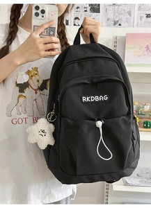Detail showing nylon backpack with RKDBAG logo, drawstring pocket and star plush charm