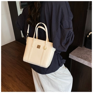 Detail of off-white lychee texture tote bag with gold metal square piece and hardware