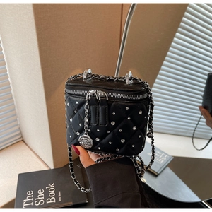 Dettaglio della mini borsa a scatola trapuntata nera con cristalli e ciondolo a rosa