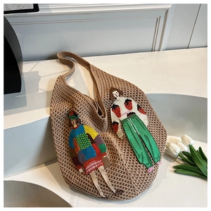 Detail of khaki crochet knit shoulder bag featuring colorful cartoon girl embroidery