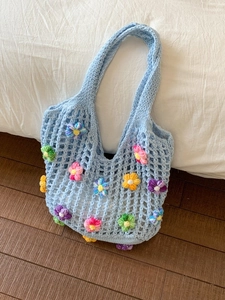 Light blue crochet tote bag with colorful 3D knitted flowers for beach vacation use