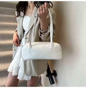 Close-up of a minimalist white Boston underarm bag made from smooth synthetic leather