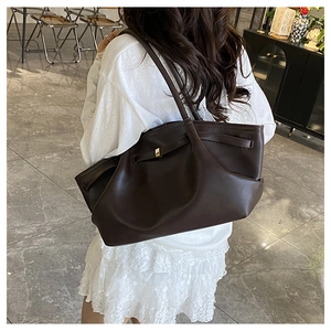 Close-up of a large dark brown leather tote bag with elegant gold buckle and soft pleats