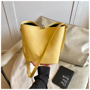 Détail du sac seau jaune grainé avec bandoulière réglable et fermoir boule argenté