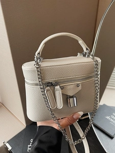 Minimalist beige box handbag with pebble grain texture and metallic chain strap detail