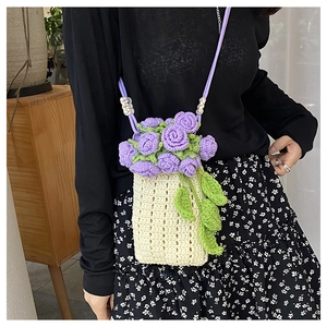 Detailed close-up of handmade crochet bucket bag with purple rose flowers and strap