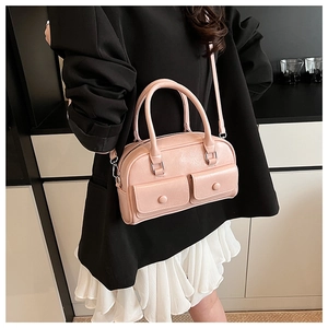 Pink faux leather Boston bag with decorative flap pockets and adjustable shoulder strap
