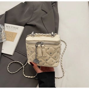 Dettaglio mini borsa bianca trapuntata con strass e ciondolo a forma di camelia