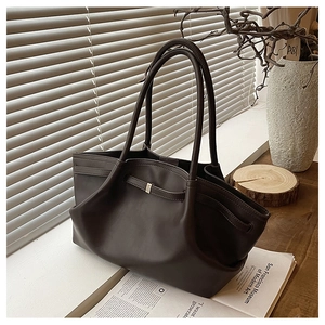 Close-up of deep brown minimalist tote bag with premium leather texture and metal buckle detail