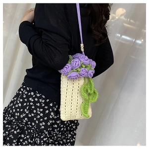 Dettaglio borsa a secchiello in maglia con fiori viola e tracolla sottile