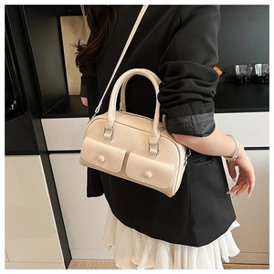 Detailed view of the front dual flap pockets and soft PU leather texture on the cream bag