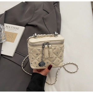 Dettaglio della borsa trapuntata bianco panna con cristalli e ciondolo a rosa