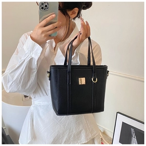 Detail of black lychee grain leather bucket bag with gold square metal hardware accent