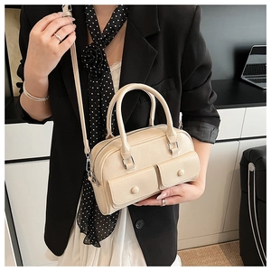 Detail of cream Boston bag with two front pockets and silver hardware on office attire