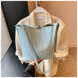 Détail du sac seau en cuir grainé bleu clair avec fermoir boule argenté et bandoulière
