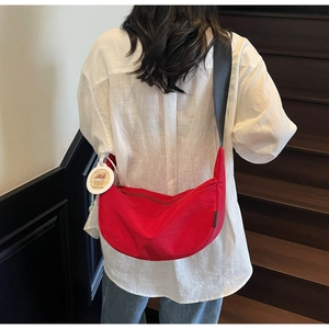Detail of red crescent bag with cute Capybara charm and adjustable black shoulder strap