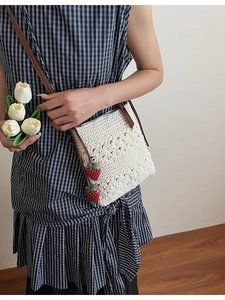 Handmade white crochet crossbody bag with floral texture and strawberry charms