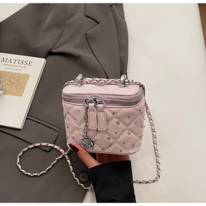 Dettaglio borsa a tracolla trapuntata rosa con strass e ciondolo a rosa