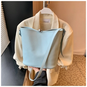 Détail du sac seau en cuir bleu clair avec un fermoir boule en métal argenté