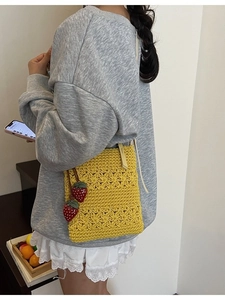 Handmade yellow crochet tote bag with woven star patterns and red strawberry charms