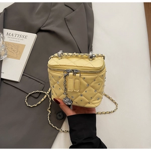 Dettaglio della mini borsa gialla trapuntata con strass e ciondolo zip a rosa