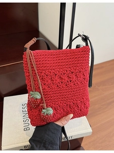 Red crochet knit crossbody bag with strawberry charms and black leather shoulder strap