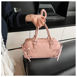 Dettaglio della borsa rosa con fiocchi decorativi e occhielli in metallo argentato