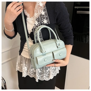 Close-up of mint green Boston bag featuring double front pockets and textured PU leather