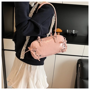 Borsa sottobraccio in vernice rosa con fiocco laterale e occhielli in metallo