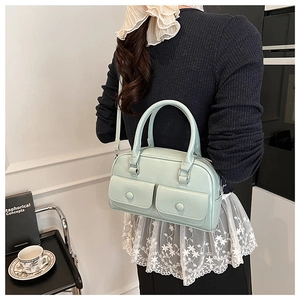 Detailed view of mint green PU leather crossbody bag with front button pockets