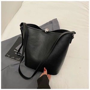 Détail du sac seau en cuir grainé noir avec fermoir à boule métallique argentée