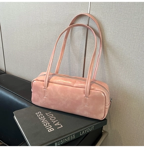 Pink glossy faux leather pillow bag with silver zipper detail and slim shoulder straps