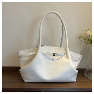 Detail of white minimalist tote bag featuring elegant side folds and leather strap buckle