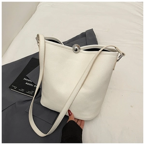 Détail du sac seau blanc avec texture litchi et boucle métallique en forme de bille