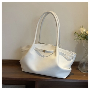 Detail of white leather tote bag featuring elegant draping and golden metal buckle accents