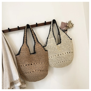 Gros plan d'un sac à bandoulière en paille fait main avec motifs ajourés