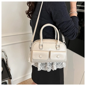 Detailed side view of a cream Boston shoulder bag on a model showing stylish daily usage