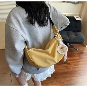 Yellow nylon crescent crossbody bag featuring a Capybara charm and colorful bead strap detail